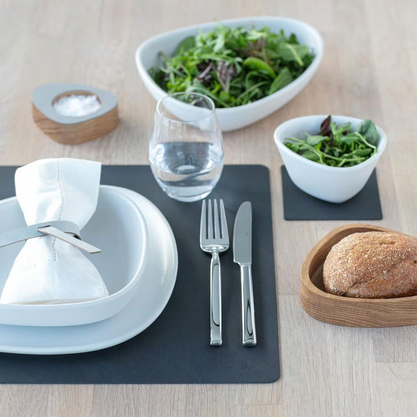 A table setting with LIND DNA square dinner mats and utensils.