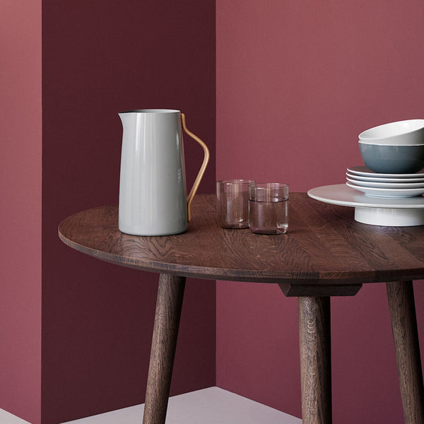 A STETLON EMMA SERVING JUG and chairs in a room with a pink wall.