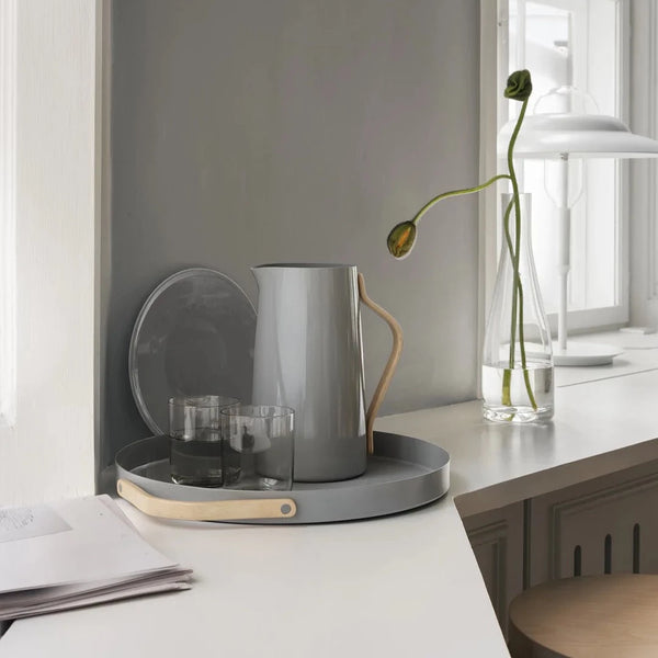 A tray on a desk with an EMMA SERVING JUG by STELTON on it.