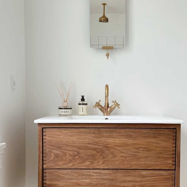 A bathroom with a wooden vanity and mirror featuring HUMDAKIN's 02 HAND SOAP ELDERBERRY + BIRCH with natural extracts.