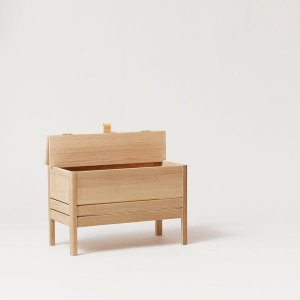 A FORM & REFINE LINE STORAGE BENCH 68 sitting on a white surface.