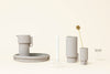 A set of ALCOA TRAY vases and a candle on a white surface by FORM & REFINE in the Gestalt Haus style.