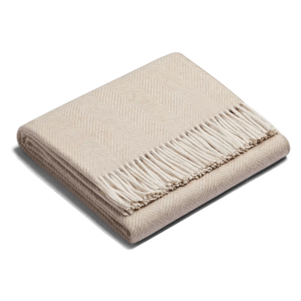 An ALPACA HERRINGBONE THROW with fringes on a white background by SIBAST, showcasing Gestalt style.