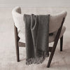 A white chair with a SIBAST ALPACA THROW from Gestalt Haus on it.