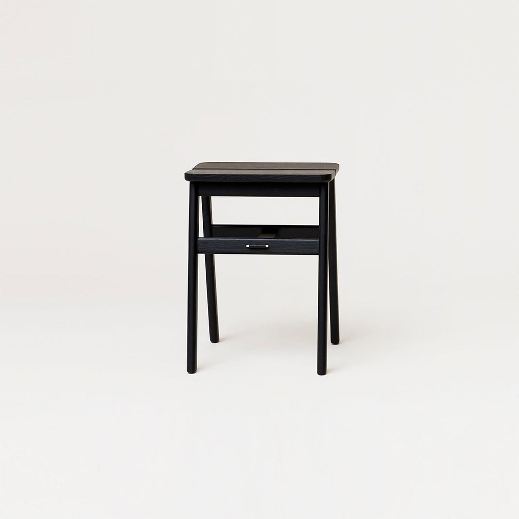 A small black FORM & REFINE side table on a white Gestalt Haus background.