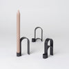 An ARCH CANDLEHOLDER VOL. 1 from KRISTINA DAM STUDIO featuring a beige candle in the Gestalt Haus style.