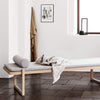 An ARCHITECTURE THROW by KRISTINA Dam STUDIO on a wooden bench in a white room with Gestalt Haus elements.