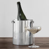 A STELTON champagne cooler by ARNE JACOBSEN complemented with a glass of champagne, creating a Gestalt Haus.