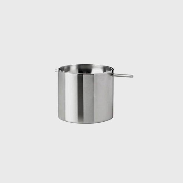 A stainless steel ARNE JACOBSEN REVOLVING ASHTRAY with a handle on a white background, designed by STELTON.
