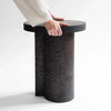 An Artesão side table from Gestalt Haus with a hand reaching up to it.