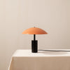 A Arundel Low Table Lamp with an orange shade sitting on top of a Gestalt Haus.