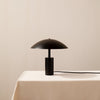 An ARUNDEL LOW TABLE LAMP by IN COMMON WITH on a white table in Gestalt Haus.