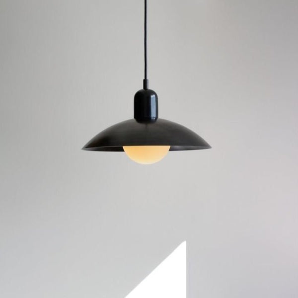 An IN COMMON WITH pendant from Gestalt Haus, hanging from a white wall.