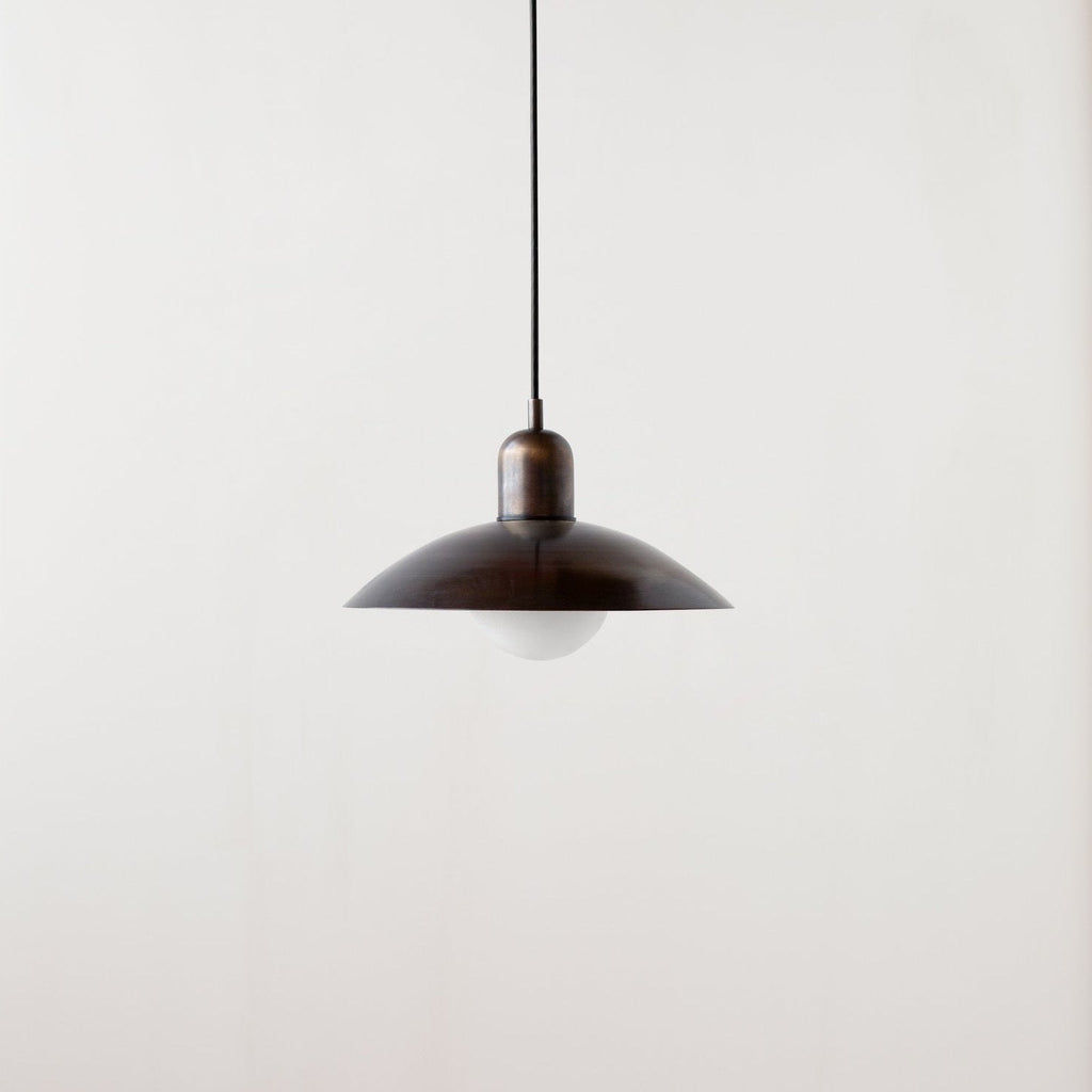 An Arundel Orb Pendant light hanging from a white wall in a Gestalt Haus setting.