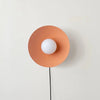 An ARUNDEL ORB SURFACE MOUNT wall lamp by IN COMMON WITH adorns a white wall with its Gestalt Haus design.