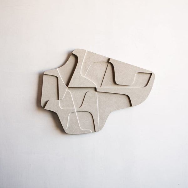 An ATELIER PLATEAU 04:15AM RELIEF sculpture, inspired by Gestalt Haus, made of concrete on a white wall.