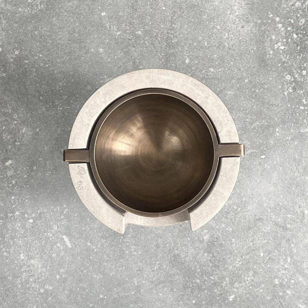 AURA OIL BURNER with a metal handle on a concrete surface at Gestalt Haus.