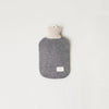 An AYMARA hot water bottle with a beige lining produced by FORM & REFINE, available at Gestalt Haus.