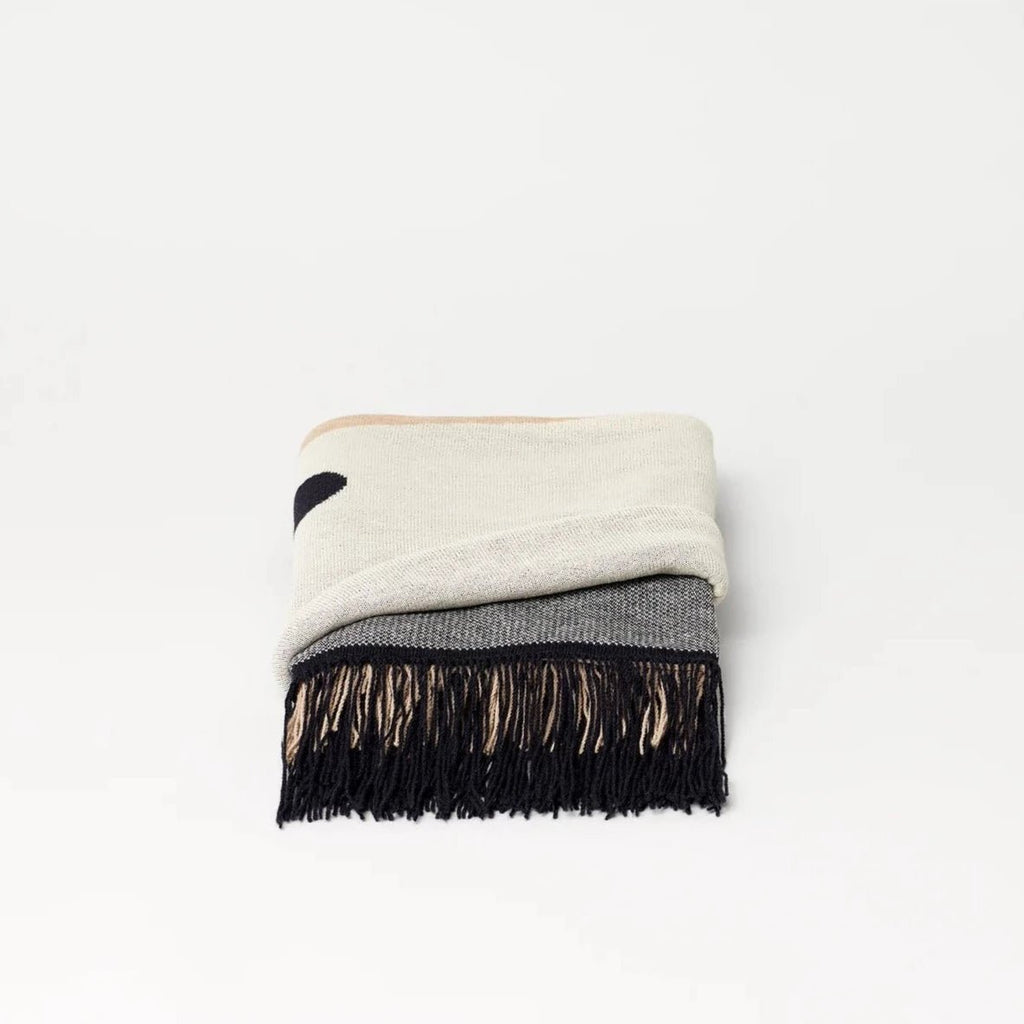 A black and white AYMARA PLAID THROWS with fringes from FORM & REFINE, embodying the essence of Gestalt Haus.