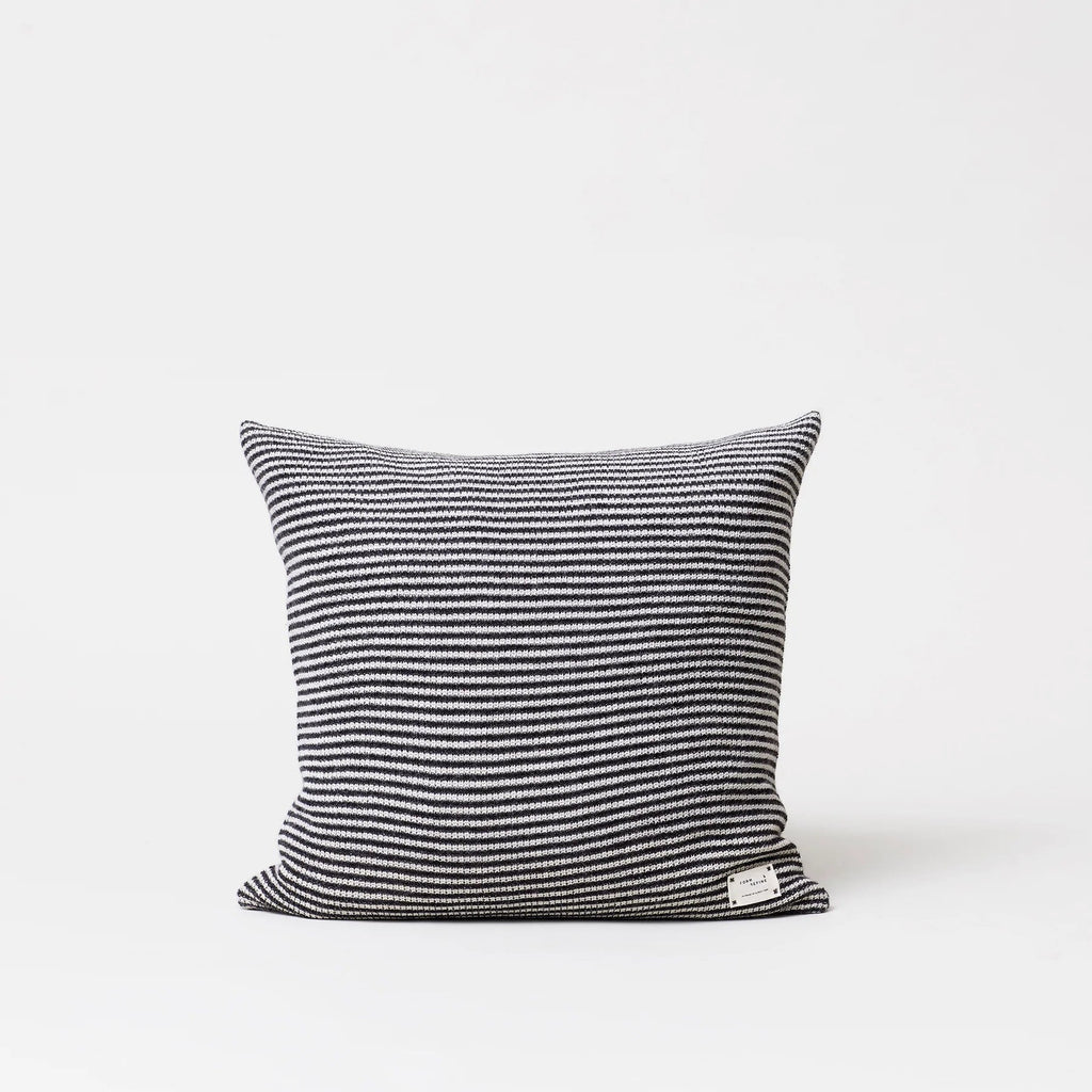 A black and white striped AYMARA SQUARE CUSHION from FORM & REFINE accompanied by Gestalt Haus on a white background.