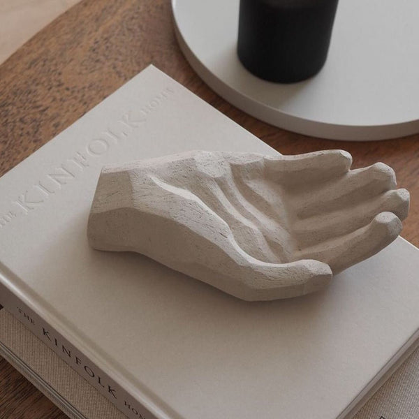 A Gestalt Haus sculpture on a table next to a book.