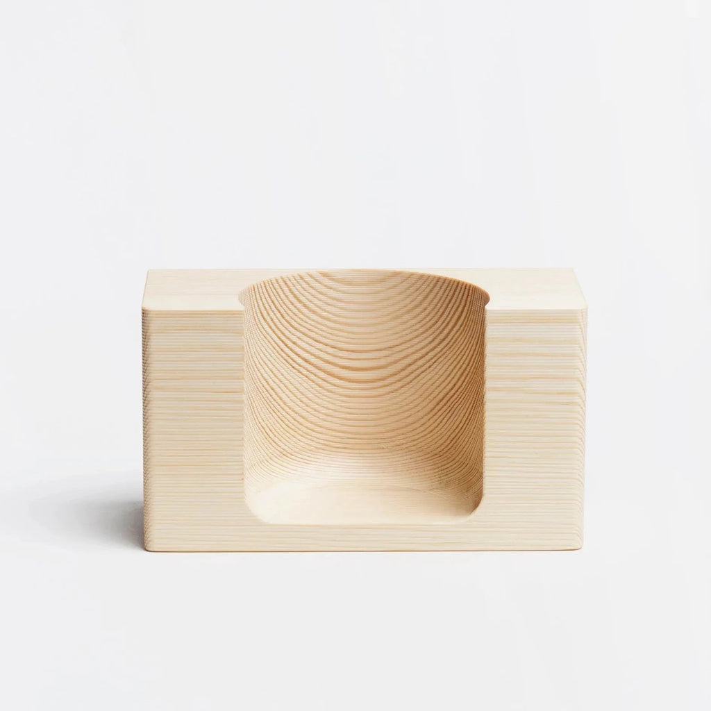 A Hetkinen soap holder with a curved shape on a white surface, inspired by the intriguing designs of Gestalt Haus.
