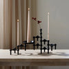 A STOFF NAGEL black candle holder on a Gestalt Haus table next to a window.
