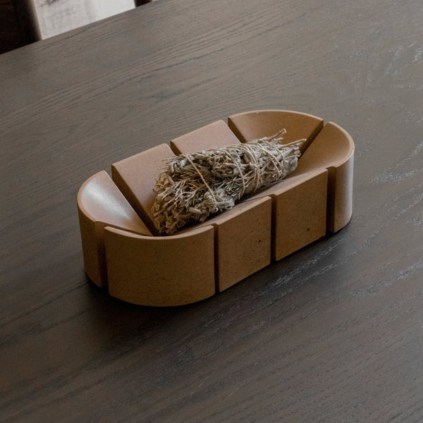 A BRUT SCULPTURES bowl sitting on top of an ORIGIN MADE table.