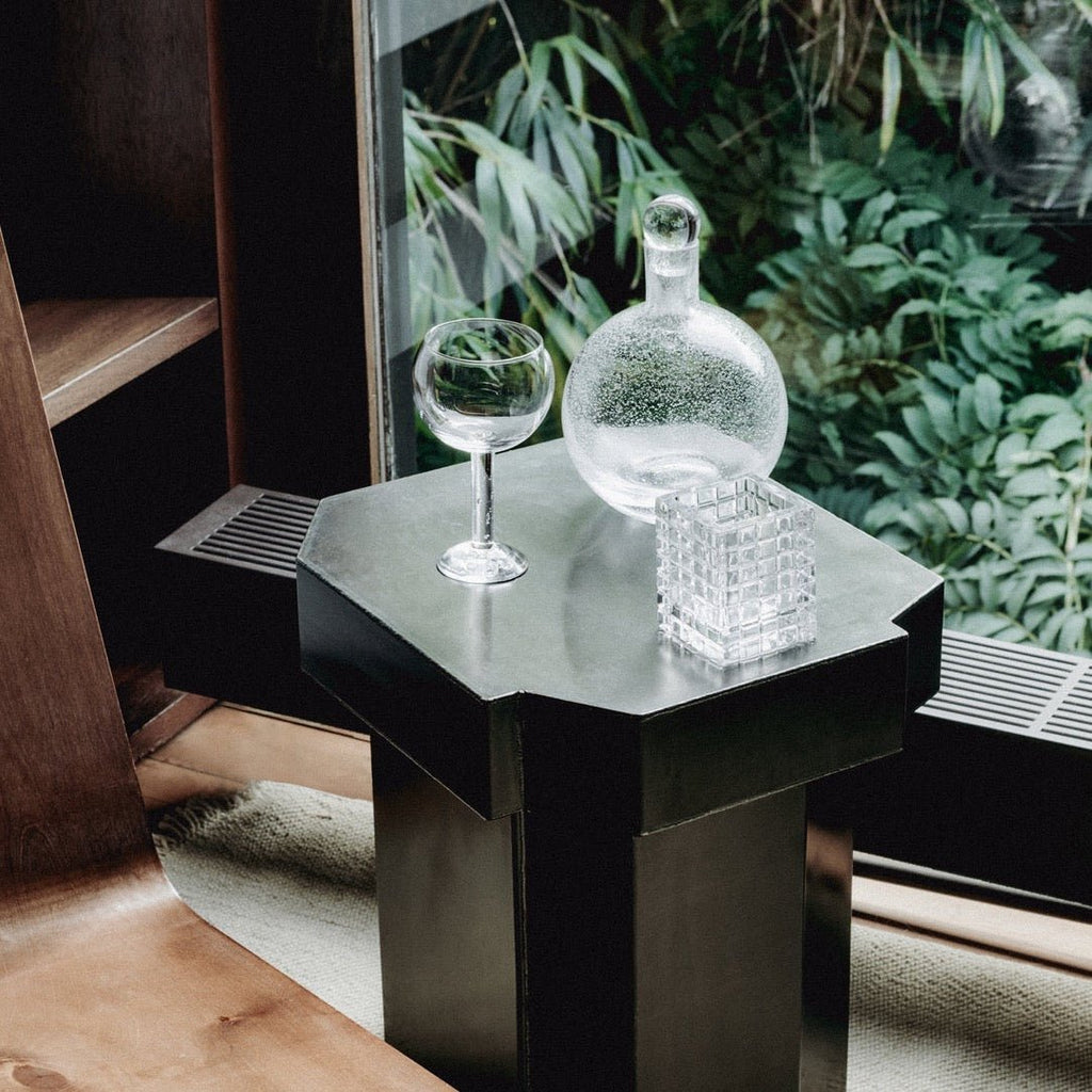 A table with a LOUISE ROE BUBBLE GLASS CARAFE on it next to a window in the Gestalt Haus.