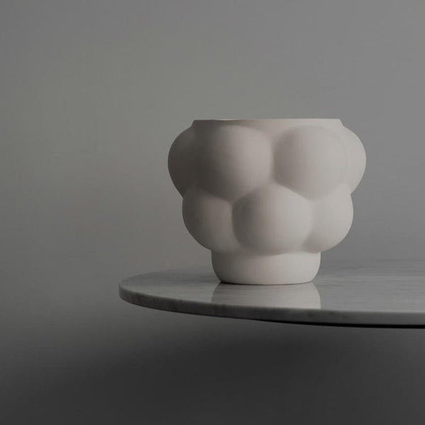 A Louise Roe Ceramic Balloon Bowl 05 sits on a table next to a gray wall in the Gestalt Haus.