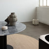 A minimalist and artistic room featuring a table, chairs, and the exquisite LOUISE ROE CERAMIC BALLOON VASE 04 GRANDE.