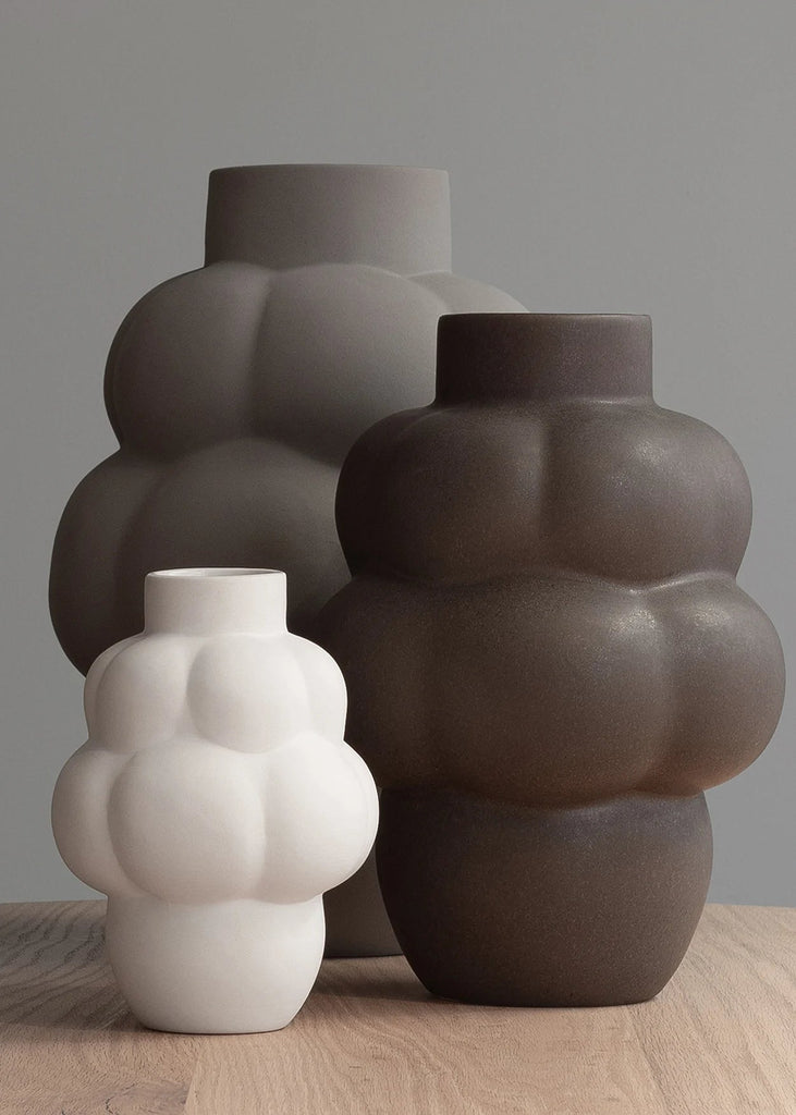 Three CERAMIC BALLOON VASE 04 PETITE vases sitting on top of a wooden table by LOUISE ROE, inspired by Gestalt Haus.