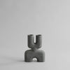 A small grey COBRA DOUBLE SCULPTURES vase with a curved shape from the brand 101 COPENHAGEN.