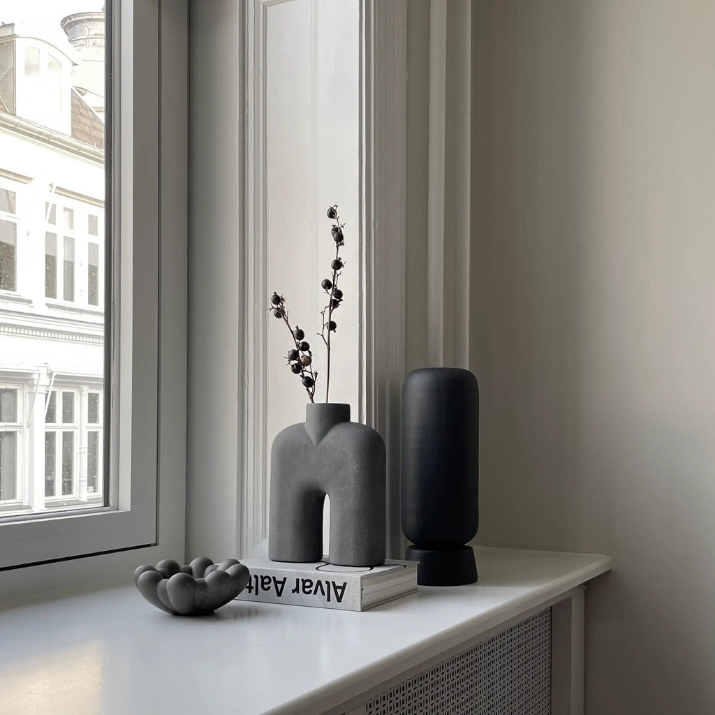 A Gestalt Haus COBRA TALL SCULPTURE by 101 COPENHAGEN sits on a window sill.