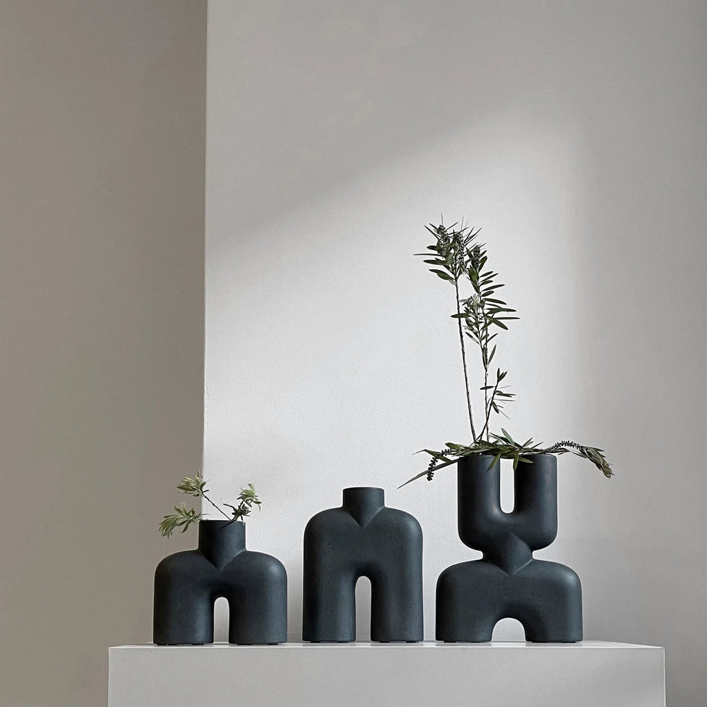 Three TALL SCULPTURES by 101 COPENHAGEN sitting on a white shelf at Gestalt Haus.