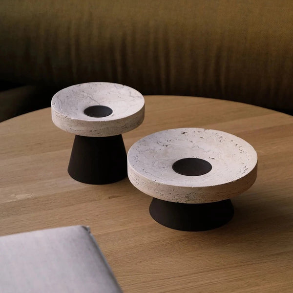Two Origin Made Coliseu Pedestals on a wooden table.