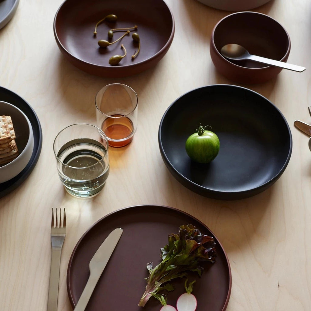 A COLOMBO TABLEWARE table with a variety of plates, bowls and utensils by AARON PROBYN in the brand name of Gestalt Haus.