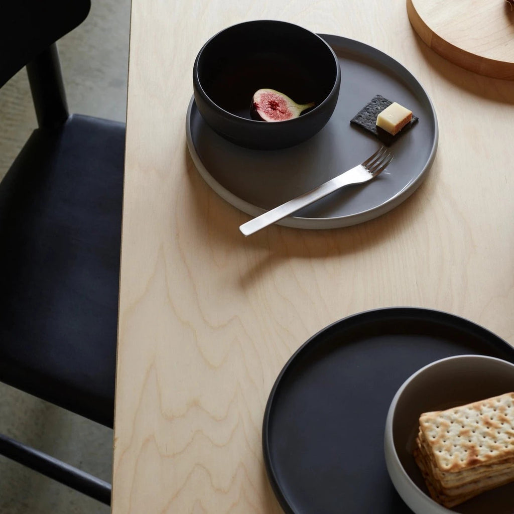 A table with COLOMBO TABLEWARE plates, bowls, and utensils from AARON PROBYN at Gestalt Haus.