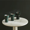 Three COMO tea light + taper candle holders by AARON PROBYN on a marble table at Gestalt Haus.