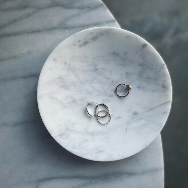 Three gold rings on a marble plate by AARON PROBYN at Gestalt Haus.