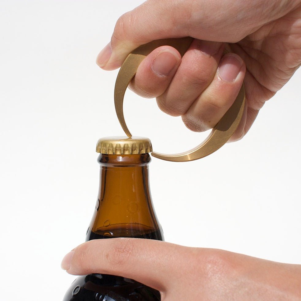 A person holding a Crescent bottle opener by Futagami at Gestalt Haus.