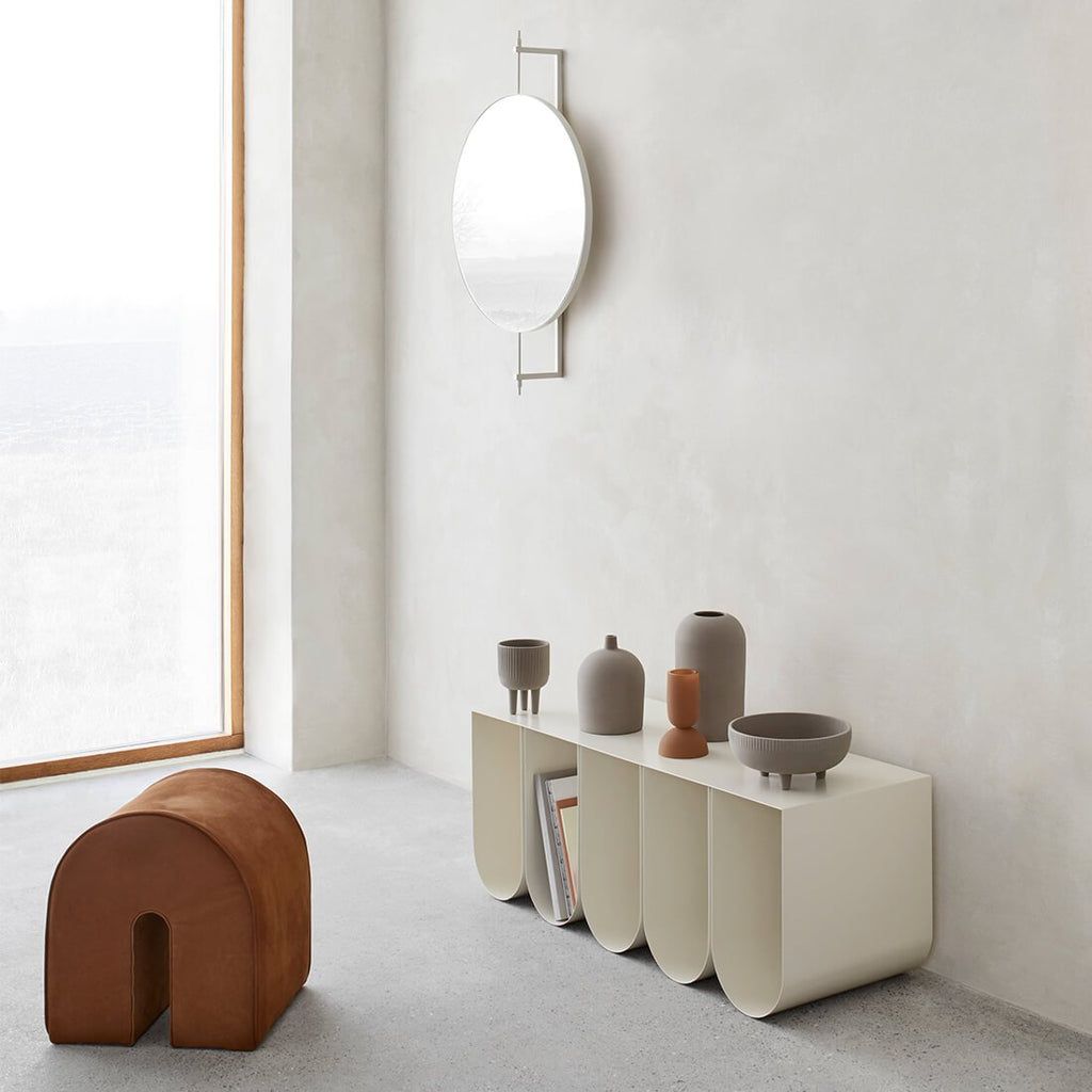 A CURVED BENCH by KRISTINA DAM STUDIO, mirrors, and vases create a harmonious ambiance in the Gestalt Haus.