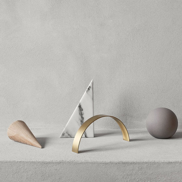 A group of KRISTINA DAM STUDIO DESK SCULPTURES made of brass and marble, displayed on a table in the Gestalt Haus.