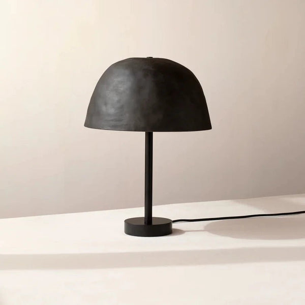 A Gestalt Haus table lamp on a white table.