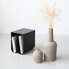 Two black Kristina Dam Studio Dome vases and a book on a white floor showcasing the minimalist aesthetic of Gestalt Haus.