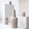 A collection of KRISTINA DAM STUDIO DOME VASES arranged on a white pedestal at Gestalt Haus.