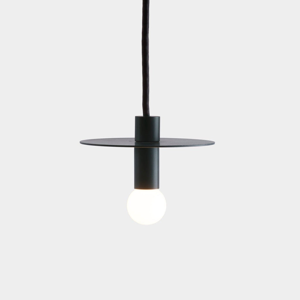 A black suspension pendant light with a white ball hanging from it by Gestalt Haus.
