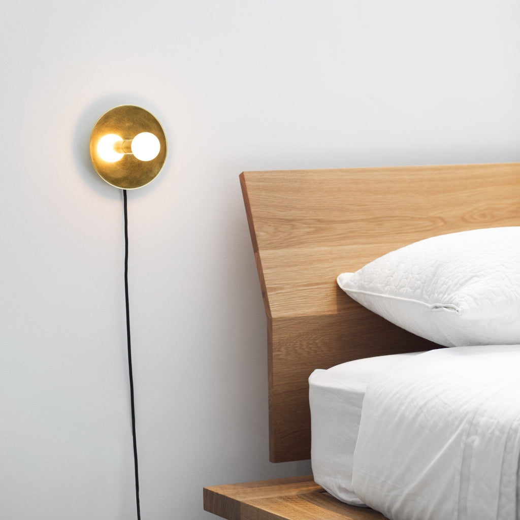 A bed with a DOT WALL LAMP by LAMBERT ET FILS next to it in the Gestalt Haus.
