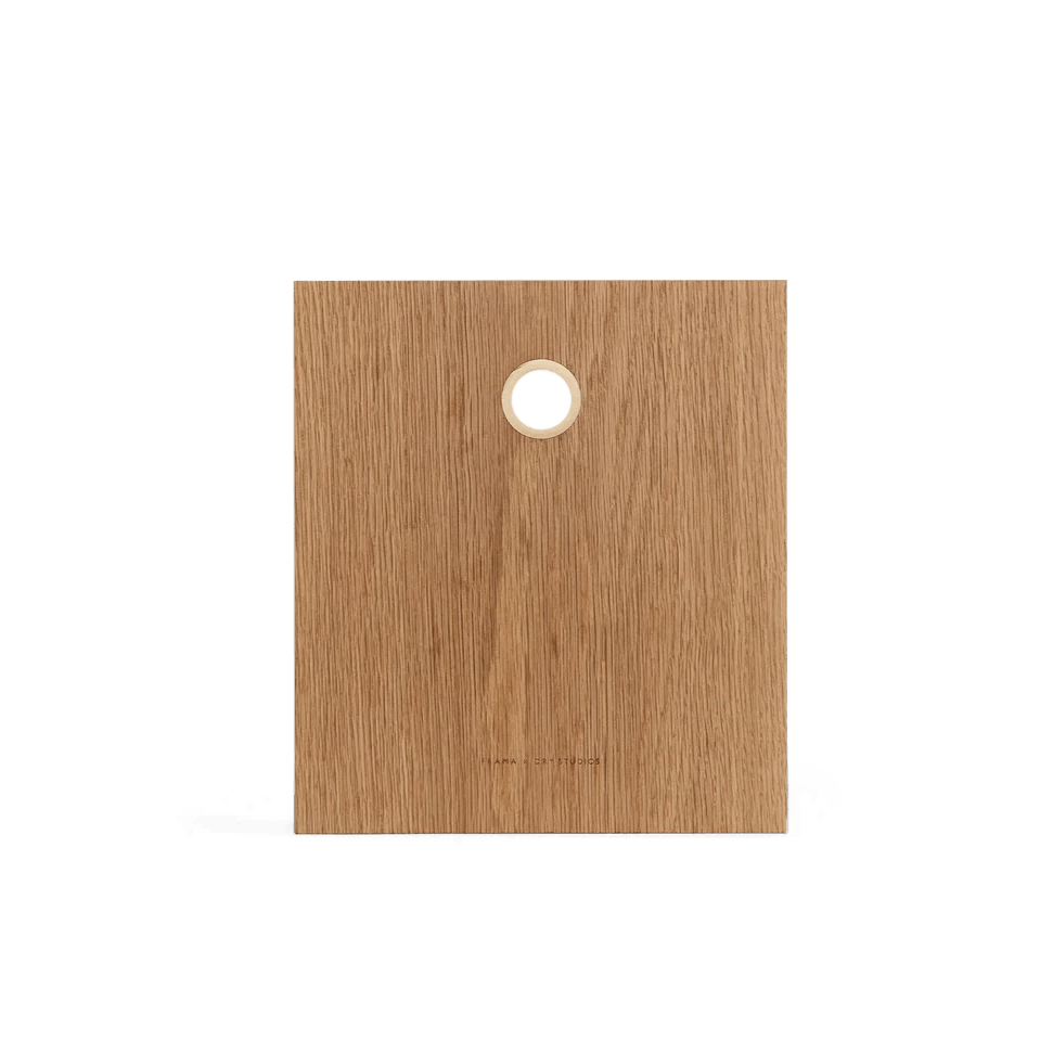 A FRAMA DRY STUDIOS OAK CUTTING BOARD with a hole in the middle.