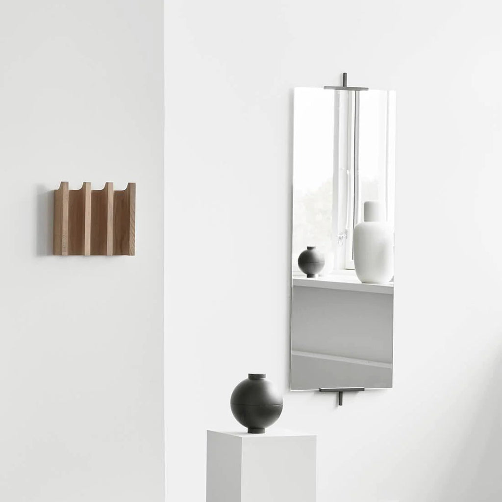 A white wall with a vase and a Kristina Dam Studio EASEL MIRROR in a Gestalt Haus.